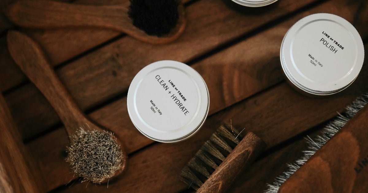 Various leather care products and brushes arranged on beige background, including cleaning and maintenance tools for handcrafted bags. Photo by Lina Verovaya on Unsplash