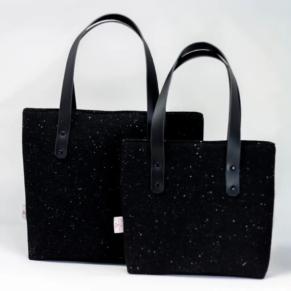 Two black with white nepps Harris Tweed® tote bags which are part of the heritage collection.