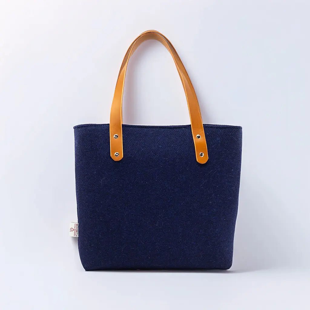 Navy Harris Tweed® Tote Bag against a white background it has mid tan straps. Part of the Tote Bags Collection