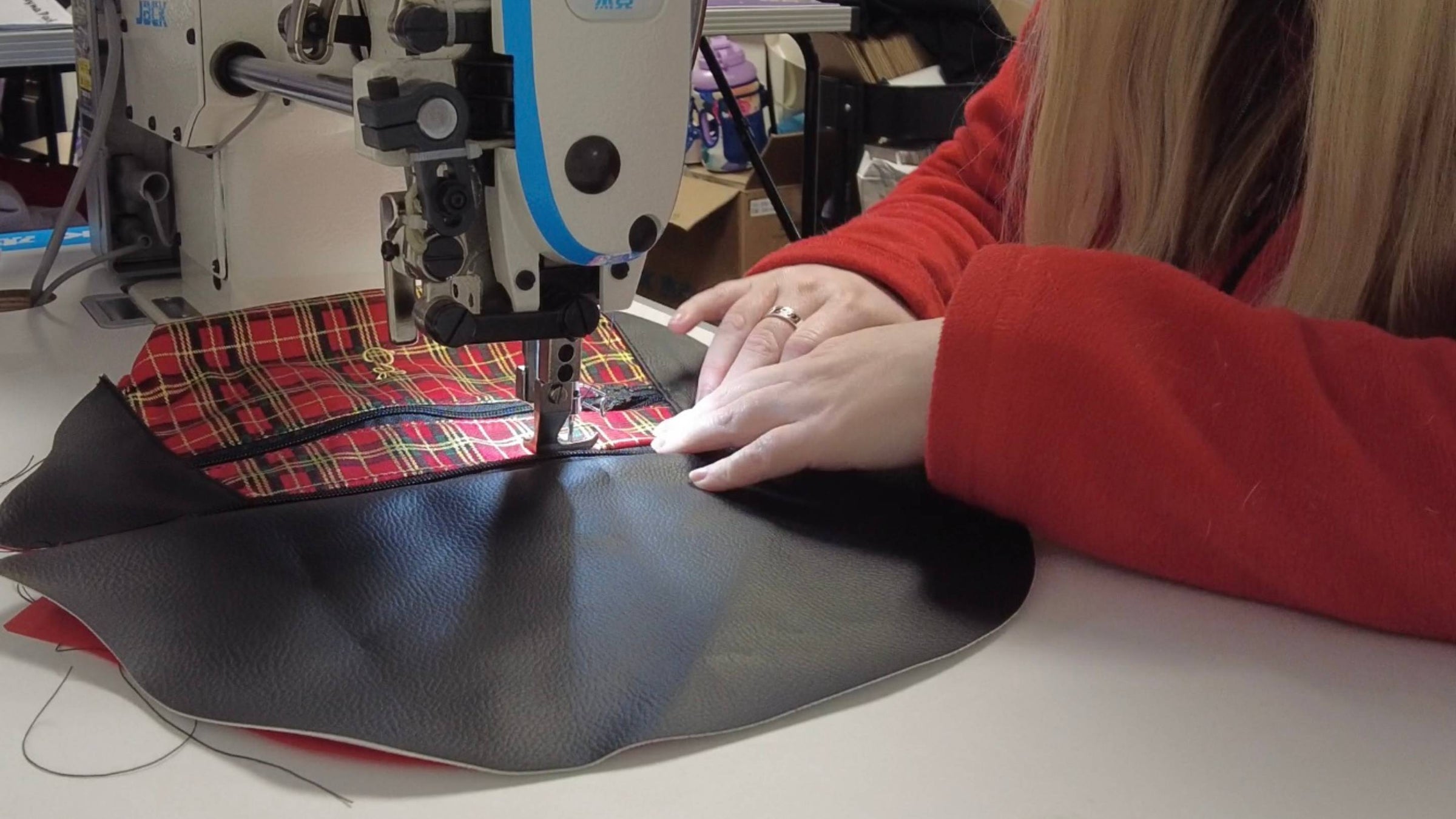 Emma Easter sewing together the Bonnie Tartan Bum Bag on an industrial sewing machine at her studio in South Wales, UK 