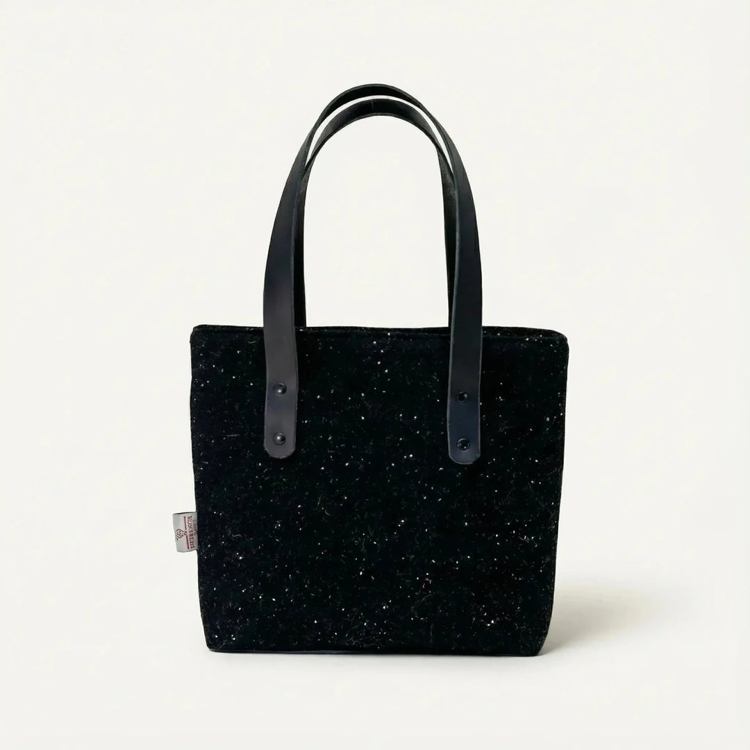 Front view of the black Harris Tweed tote bag with black leather handles, handcrafted in Wales by Emma Easter