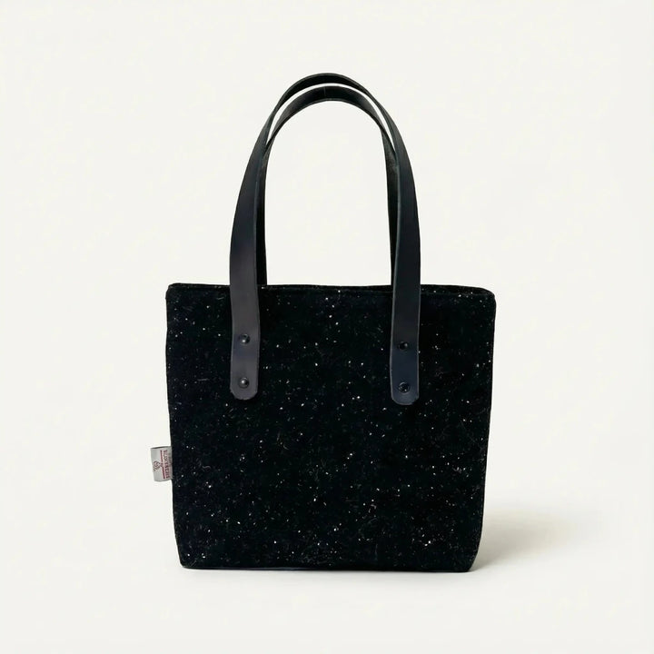 Front view of the black Harris Tweed tote bag with black leather handles, handcrafted in Wales by Emma Easter