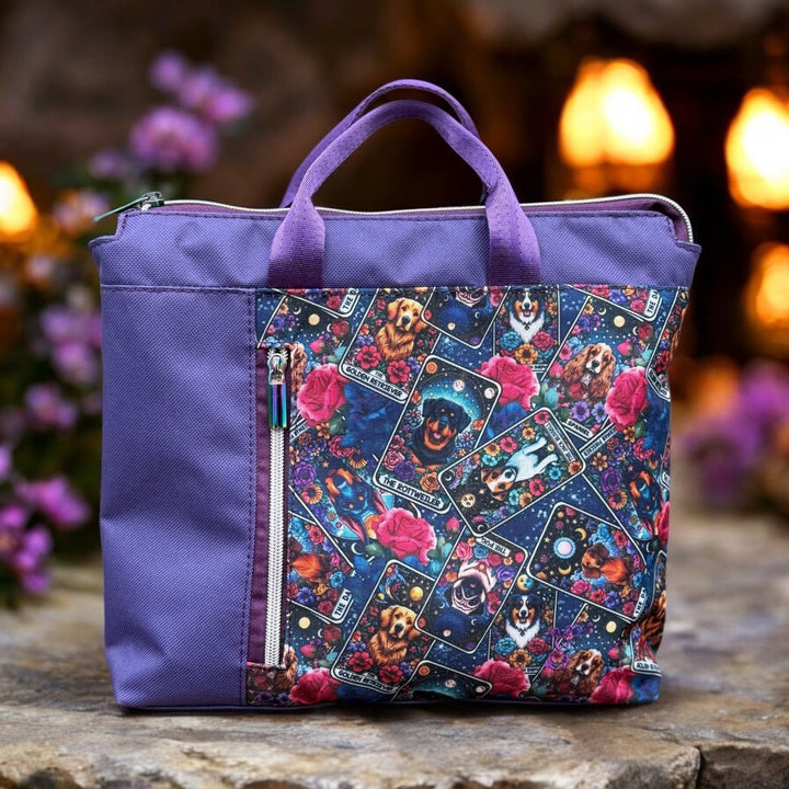 Artisan-made backpack with vibrant dog-themed tarot card print, crafted from water-resistant canvas and waterproof purple body, set against glowing garden lights.