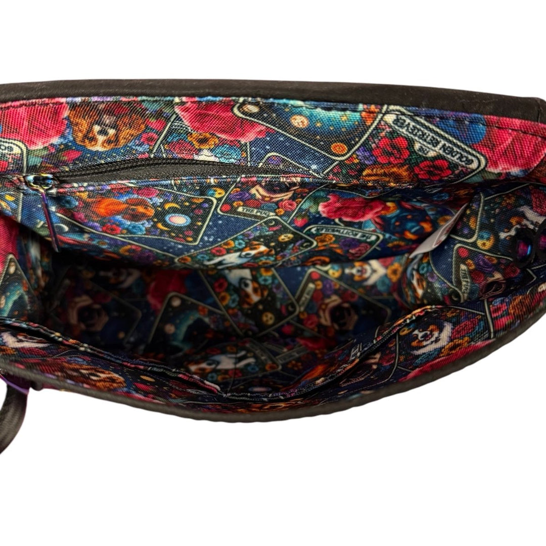Open view of the Dogs of Tarot Crossbody bag interior showing a bold tarot dog print lining with an internal zip pocket and divided slip pocket.