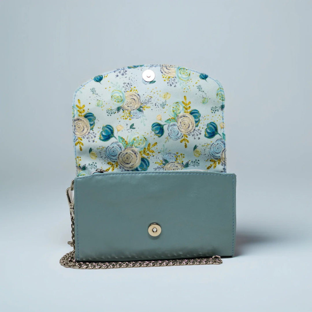 Floral-patterned leather handbag with a light blue base made in Wales by Emma Easter Handcrafted