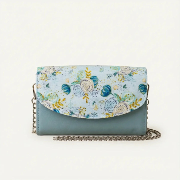 Eira leather mini handbag in powder blue and floral flap design, featuring a silver chain strap and compact handcrafted silhouette.