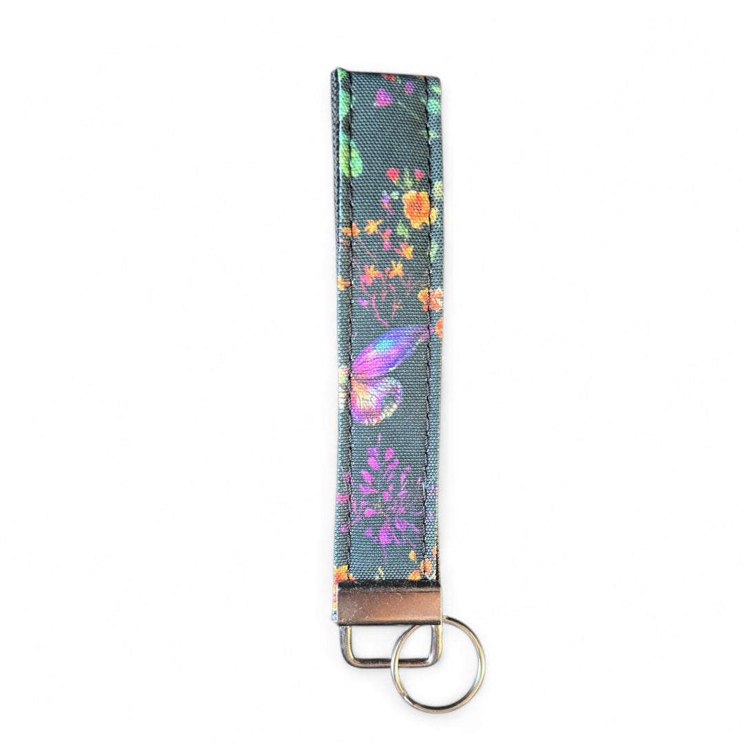 Handcrafted butterfly key fob | Emma Easter Handcrafted in Wales | Colourful wristlet with butterfly and wildflower design on gray background