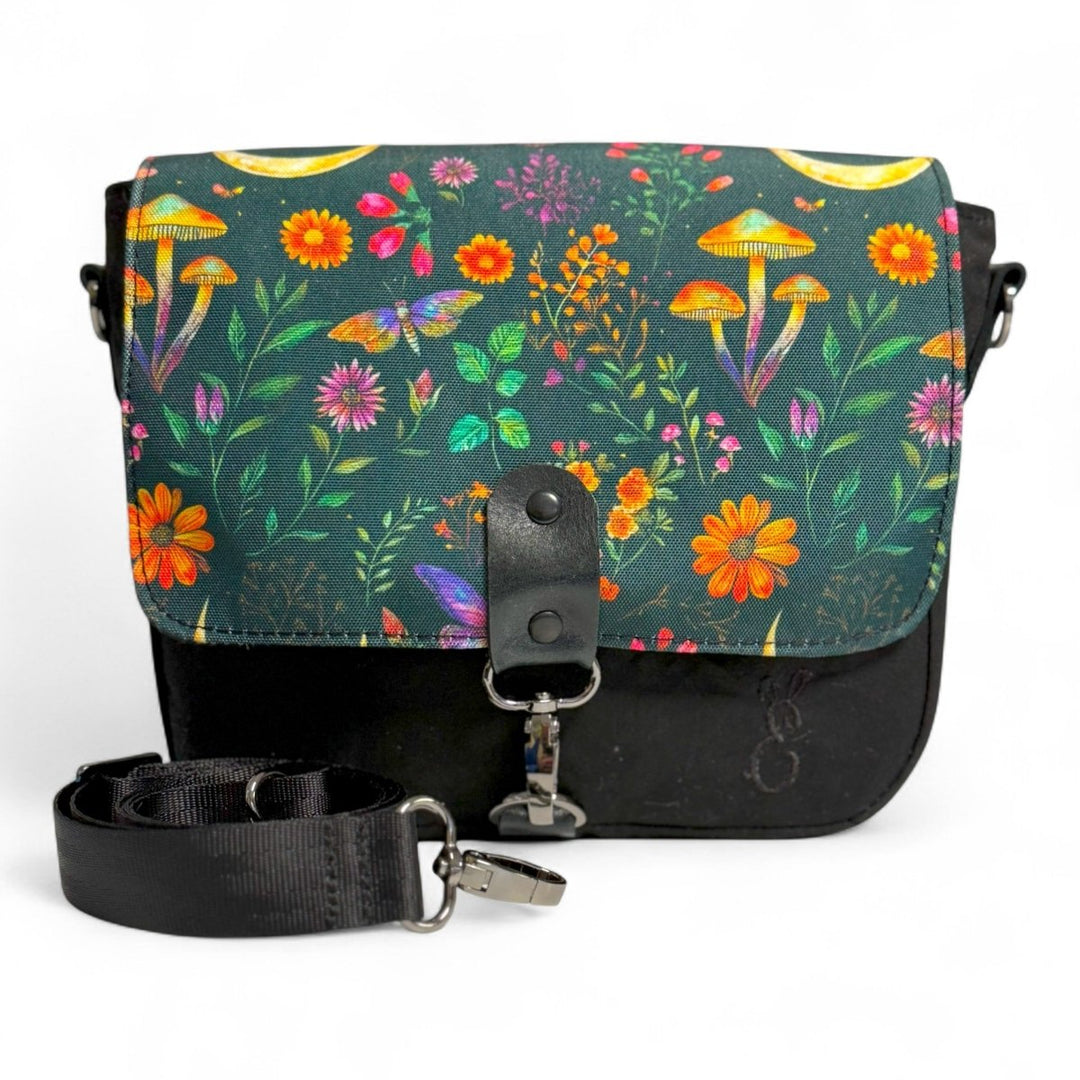 Enchanted Woodland crossbody bag with moon and mushroom print flap, handcrafted from organic cotton oilskin and black canvas.
