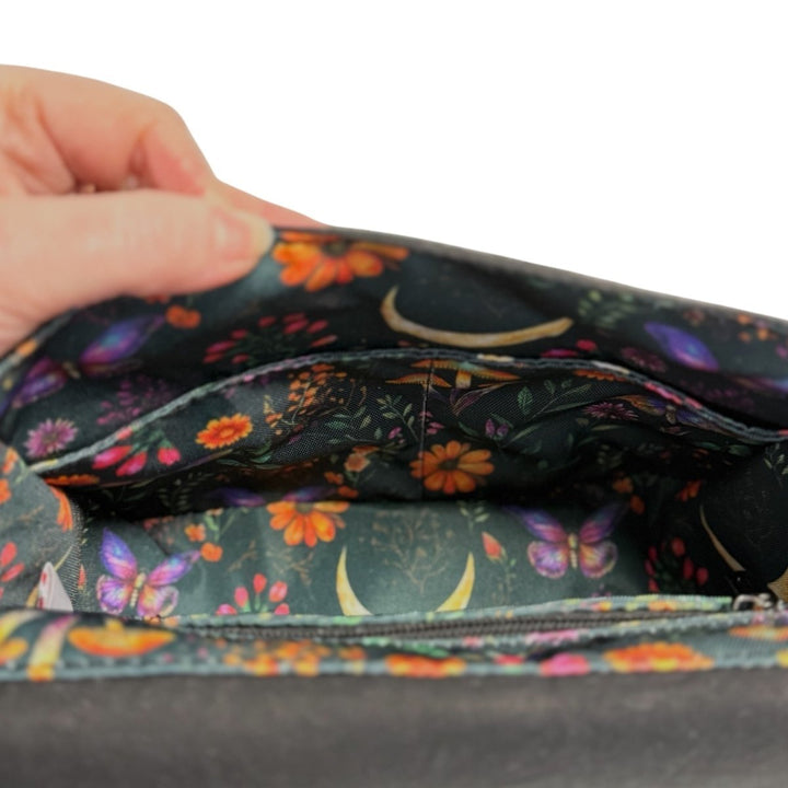 Interior view of the Enchanted Woodland Crossbody Bag, showcasing a charming woodland print lining filled with wildflowers, butterflies, and mushrooms. Includes a zipped pocket and divided slip pocket for everyday organisation.