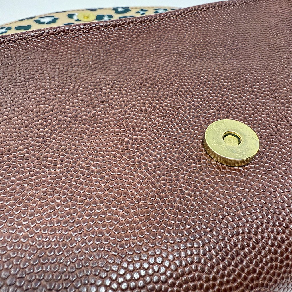 Close-up of textured brown leather exterior with magnetic gold snap closure by Emma Easter