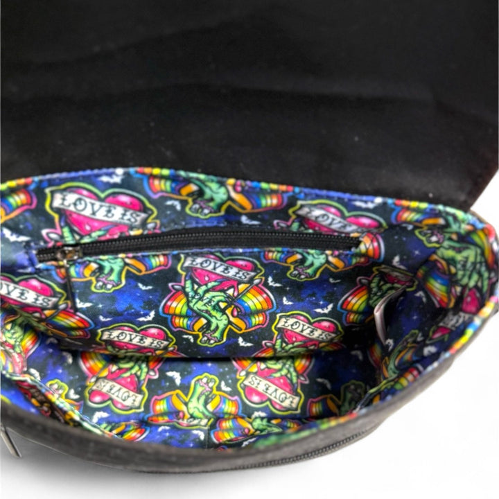 Interior view of Love is Love zombie Pride crossbody bag showing colorful water-resistant lining with rainbow pattern