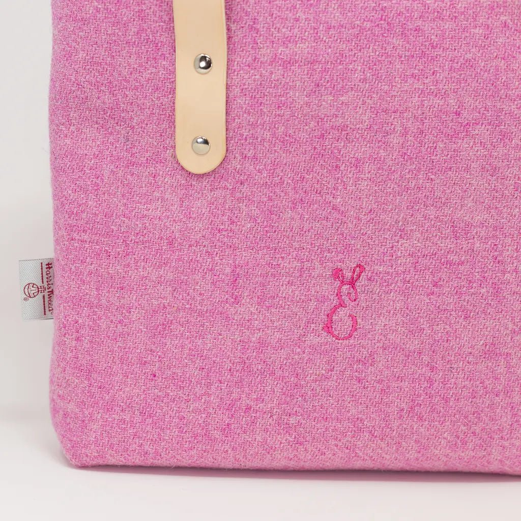 Close-up of embroidered Emma Easter bunny logo on the Penelope Harris Tweed pink tote bag.