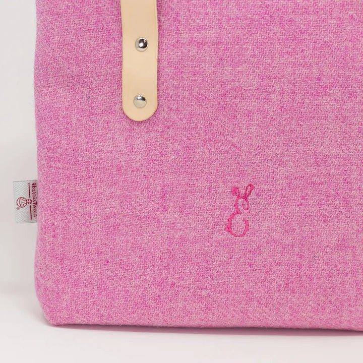 Close-up of embroidered Emma Easter bunny logo on the Penelope Harris Tweed pink tote bag.