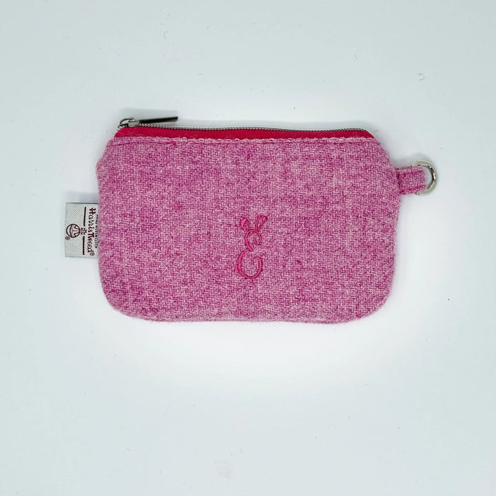 Pink Harris Tweed® pouch with a logo on a white background