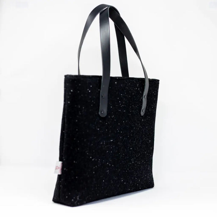 Angled side view of the black Harris Tweed tote bag with Harris Tweed® and black leather handles by Emma Easter Handcrafted.