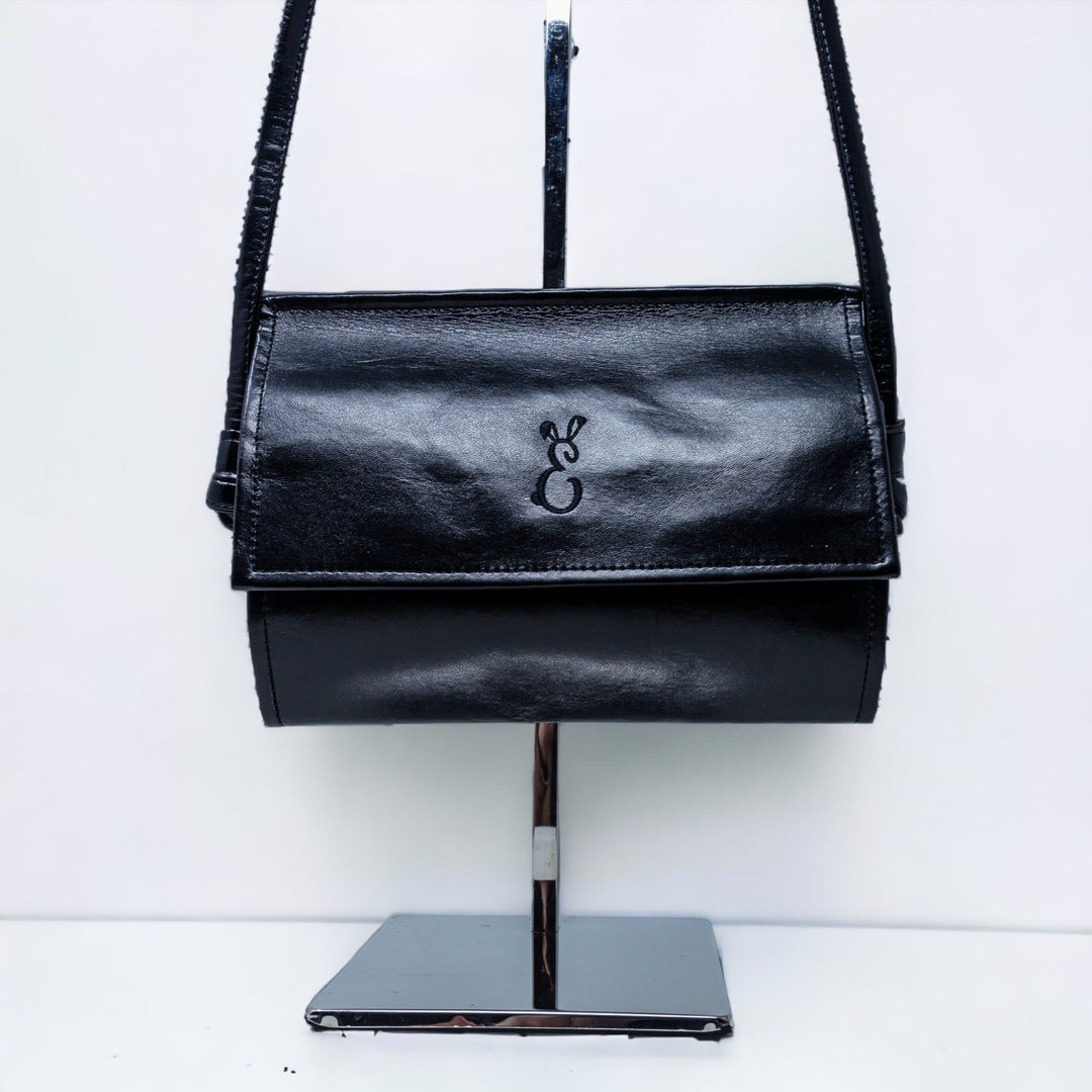 front view of the black rosa janine cross body bag showing the Emma Easter 'E' bunny logo